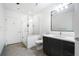 Well-lit bathroom featuring a glass-enclosed shower, dark wood vanity, and modern gray tile flooring at 1080 Peachtree Ne St # 1610, Atlanta, GA 30309