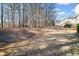 Sloped backyard with steps leading to an upper area surrounded by mature trees at 1775 Unity Loop, Cumming, GA 30040