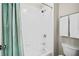Full tub and shower featuring white tile and a curtain. A toilet and towel rack are also present at 1775 Unity Loop, Cumming, GA 30040