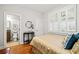 Cozy bedroom with hardwood floors, shuttered windows, and ensuite bathroom with dark wood cabinetry at 1775 Unity Loop, Cumming, GA 30040