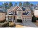 Charming two-story brick home with a welcoming front porch and a well-manicured lawn at 1775 Unity Loop, Cumming, GA 30040