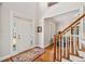 Bright foyer featuring hardwood floors and a classic staircase, adjacent to a sunlit living area at 1775 Unity Loop, Cumming, GA 30040