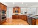 Gourmet kitchen with double ovens, stainless steel appliances, hardwood floors, and dark wood cabinetry at 1775 Unity Loop, Cumming, GA 30040