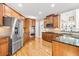 Spacious kitchen featuring stainless steel appliances, granite countertops, wood cabinetry, and hardwood floors at 1775 Unity Loop, Cumming, GA 30040