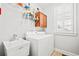 Bright laundry room with sink, shaker cabinets, washer, dryer, and window at 1775 Unity Loop, Cumming, GA 30040