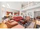 Inviting living room with high ceilings, rich hardwood floors, and views into the kitchen and formal sitting room at 1775 Unity Loop, Cumming, GA 30040