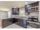 Modern kitchen features stainless steel appliances, dark cabinets, and granite countertops at 1157 Helen St, Morrow, GA 30260