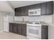 Modern kitchenette with granite countertops, white appliances, and black cabinetry at 1157 Helen St, Morrow, GA 30260