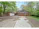Sprawling red brick home with an attached two-car garage and mature landscaping around the front yard at 4367 S Berkeley Lake Nw Rd, Duluth, GA 30096
