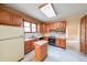 Traditional kitchen with wood cabinets, black appliances and a portable wooden island at 4367 S Berkeley Lake Nw Rd, Duluth, GA 30096