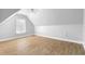 Attic area with laminate flooring, ceiling fan, and natural light from a window at 1920 Lee Patrick Dr, Dacula, GA 30019