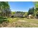 Expansive backyard boasts mature trees, deck, a lush lawn, and a charming playhouse at 1920 Lee Patrick Dr, Dacula, GA 30019