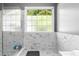 Bathroom featuring a frameless glass shower with an elegant shower and marble tile at 1920 Lee Patrick Dr, Dacula, GA 30019