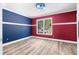 Colorful bedroom featuring hardwood floors, fresh paint, natural light from a large window, and stylish color palette at 1920 Lee Patrick Dr, Dacula, GA 30019