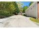 Long driveway leading to a two-car garage surrounded by lush greenery and mature trees at 1920 Lee Patrick Dr, Dacula, GA 30019