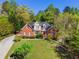 Beautiful two-story home surrounded by mature trees, showcasing its inviting entrance and well-manicured lawn at 1920 Lee Patrick Dr, Dacula, GA 30019