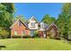 Charming brick and stucco two-story home with well-maintained lawn and mature trees, perfect for curb appeal at 1920 Lee Patrick Dr, Dacula, GA 30019