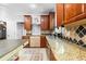 Kitchen featuring granite countertops, tile backsplash, stainless steel appliances, and wood cabinets at 1920 Lee Patrick Dr, Dacula, GA 30019