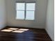 Bedroom with wood flooring, a bright window, and white walls at 5099 Noble Village Way, Lilburn, GA 30047