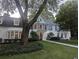 Charming two-story home with white brick and blue accents, complemented by lush greenery at 499 Johnson Ferry Nw Rd, Atlanta, GA 30328