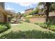 Spacious backyard with a covered patio, lush lawn, brick wall and manicured landscaping at 1520 Camden Cove Dr, Cumming, GA 30040