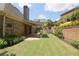 Spacious backyard with a covered patio, lush lawn, and manicured landscaping at 1520 Camden Cove Dr, Cumming, GA 30040