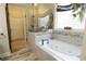 Spa-like bathroom featuring a large soaking tub with tile surround and decorative accents at 1520 Camden Cove Dr, Cumming, GA 30040