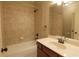Neutral bathroom features a tub with tile surround, a vanity with sink, and bronze fixtures at 1520 Camden Cove Dr, Cumming, GA 30040