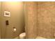 Bathroom featuring neutral-toned tile shower, toilet, and wall decor at 1520 Camden Cove Dr, Cumming, GA 30040