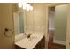 Bathroom with vanity and sink, complemented by a large mirror and wood flooring in the hallway at 1520 Camden Cove Dr, Cumming, GA 30040