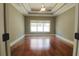 Spacious bedroom featuring a tray ceiling, a ceiling fan and a window with a view of the outdoors at 1520 Camden Cove Dr, Cumming, GA 30040