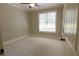 A bright bedroom with neutral carpet and trim, a ceiling fan, and a large window with blinds at 1520 Camden Cove Dr, Cumming, GA 30040