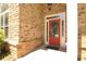 Close-up of the entryway, showing the red front door with decorative glass, set in a brick facade at 1520 Camden Cove Dr, Cumming, GA 30040