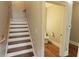 Staircase leading to a half-bathroom with wood floors, adding a touch of warmth and elegance at 1520 Camden Cove Dr, Cumming, GA 30040