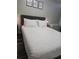 Bedroom featuring a comfortable bed with white patterned bedding, upholstered headboard, and framed artwork at 215 Piedmont Ne Ave # 304, Atlanta, GA 30308