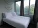 Bright bedroom featuring a comfy bed with white patterned bedding, window with curtains, and tassel decoration at 215 Piedmont Ne Ave # 304, Atlanta, GA 30308