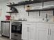 A modern kitchen featuring stainless steel appliances, white cabinets, and stylish open shelving at 215 Piedmont Ne Ave # 304, Atlanta, GA 30308