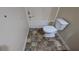 Clean bathroom with a white toilet and bathtub featuring decorative, multi-shaded flooring at 7128 Crystal Creek Pl, Douglasville, GA 30134
