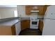 Kitchen with wood cabinets, white appliances, and laminate counters at 7128 Crystal Creek Pl, Douglasville, GA 30134