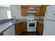 Cozy kitchen featuring wood cabinets, laminate countertops, and white appliances at 7128 Crystal Creek Pl, Douglasville, GA 30134