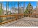 Large back deck with wood railing surrounded by mature trees and nature at 2018 Sugar Maple Ln, Woodstock, GA 30189
