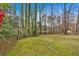 Green backyard space surrounded by wooden fence and tall trees, perfect for outdoor activities and privacy at 2018 Sugar Maple Ln, Woodstock, GA 30189