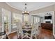 Dining area with table and chairs, bright windows, and stylish chandelier at 2018 Sugar Maple Ln, Woodstock, GA 30189