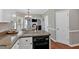Open-concept kitchen featuring granite counters, white cabinets, and black dishwasher at 2018 Sugar Maple Ln, Woodstock, GA 30189