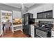 Eat-in kitchen featuring white cabinets, granite counters, and black appliances at 2018 Sugar Maple Ln, Woodstock, GA 30189
