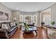 Living room featuring hardwood floors, leather furniture, and views of the front entrance at 2018 Sugar Maple Ln, Woodstock, GA 30189