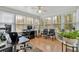 A sunroom with hardwood floors and many windows allows for an office or work area at 2018 Sugar Maple Ln, Woodstock, GA 30189