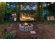 Backyard image featuring a stone fire pit circled by blocks of seating and strung with lights at 3851 Westwick Nw Way, Kennesaw, GA 30152