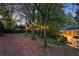 Twilight image of backyard, showcasing mature trees with charming string lights at 3851 Westwick Nw Way, Kennesaw, GA 30152