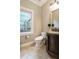Well-lit half bathroom featuring a modern toilet, vanity with granite countertop, and tiled floors at 3851 Westwick Nw Way, Kennesaw, GA 30152